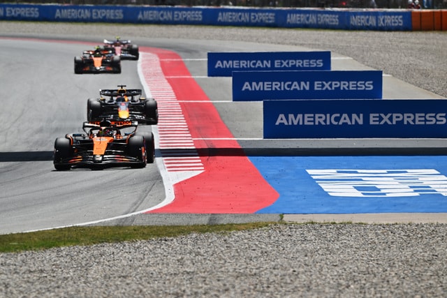 Tres coches Formula 1 en una curva, junto al logo de American Express.