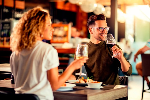 Una pareja disfruta de la comida y las bebidas en un restaurante de moda.