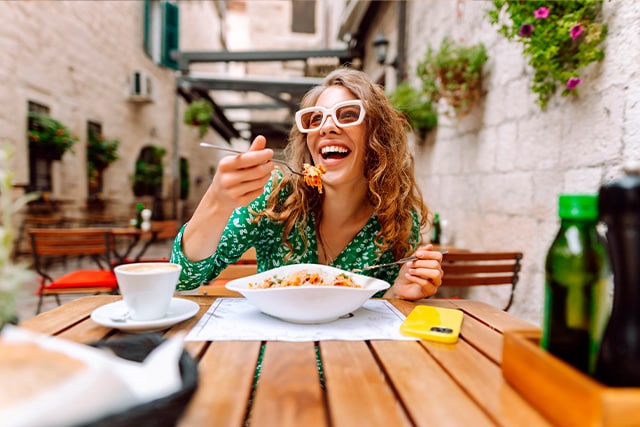 Mujer disfrutando de una comida al aire libre.