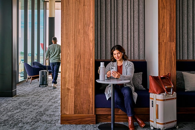Una mujer en una lujosa sala VIP de aeropuerto, esperando su vuelo.