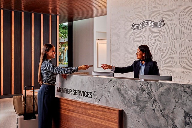 Mujer llegando a una sala VIP de American Express.
