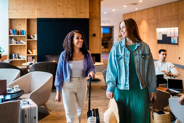 Dos compañeras de trabajo en una sala VIP de un aeropuerto.