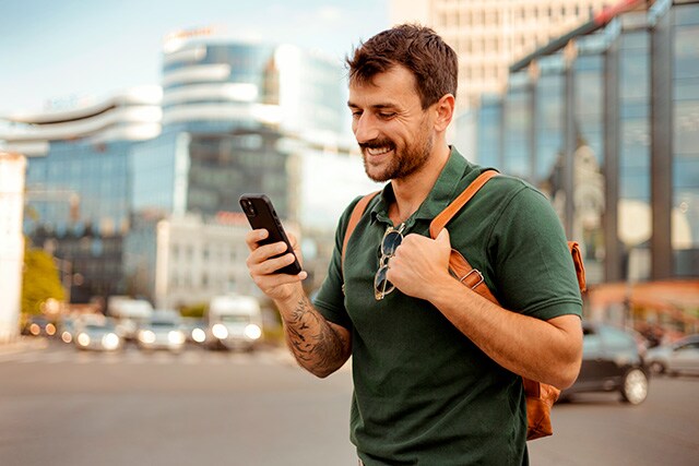 Hombre con su teléfono celular en la calle.