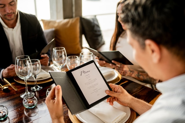 Primer plano de un hombre mirando el menú en un restaurante.