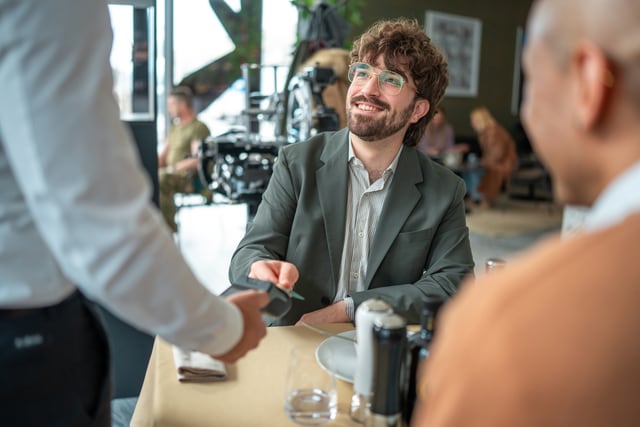 Una pareja de jóvenes disfruta de una excelente experiencia gastronómica en un sofisticado restaurante.