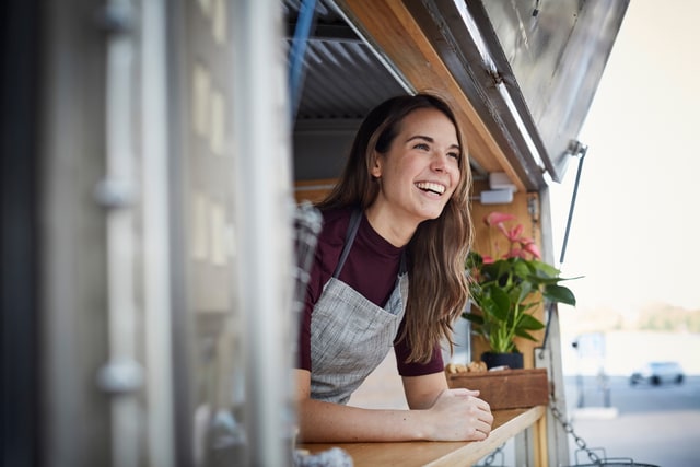Mujer sonriendo en su pequeño negocio.