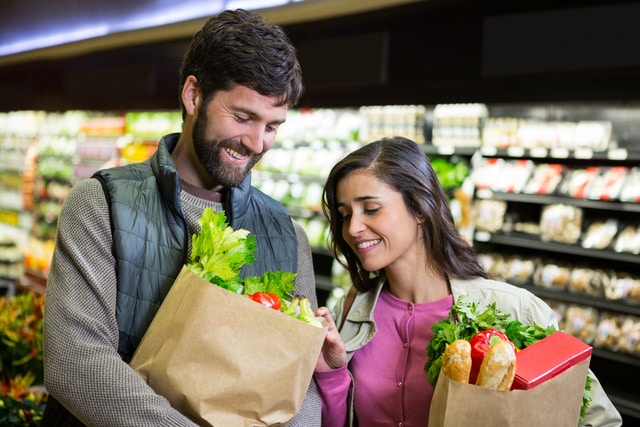 Pareja comprando verduras en la sección orgánica del supermercado.