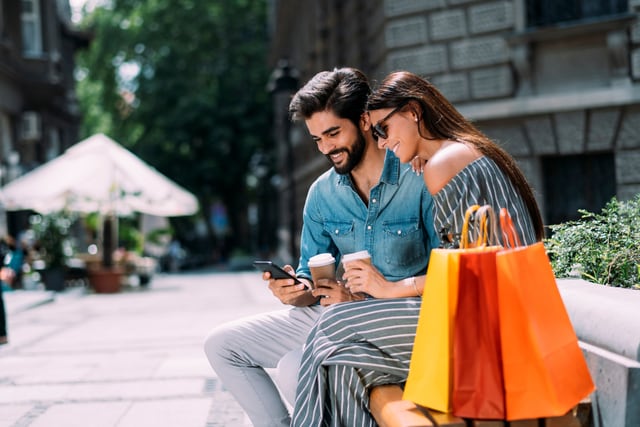 Pareja joven con bolsas de compras en la ciudad.