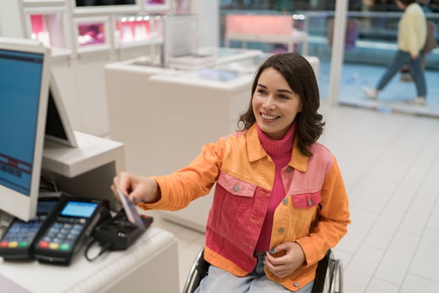 Mujer paga con una tarjeta de crédito en una tienda