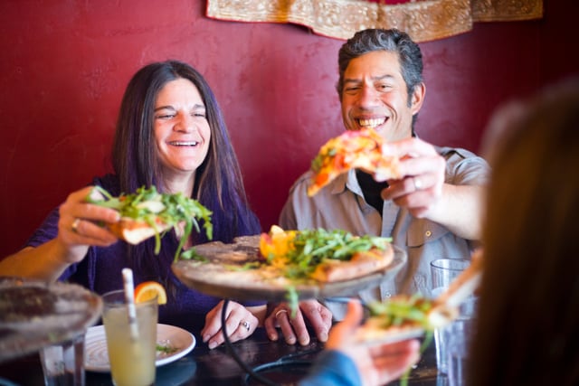 Una pareja compartiendo una pizza en un restaurante.