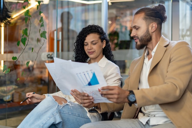 Un hombre y una mujer trabajando en equipo y planificando con documentos en la oficina.