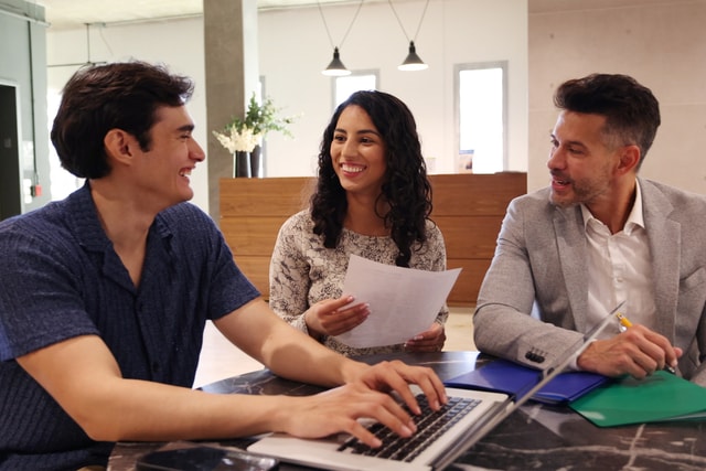 Grupo de empleados sentados en una mesa para tener una conversación.