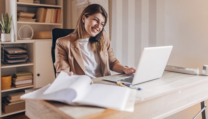 Mujer empresaria en su despacho, trabajando en una computadora.