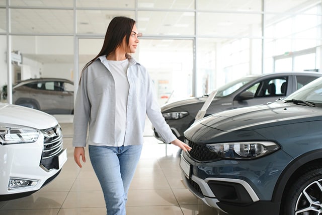 Una mujer pasea entre los nuevos modelos de autos en una agencia.