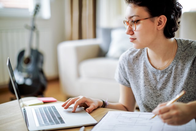 Mujer trabajando en su computadora portátil en casa.