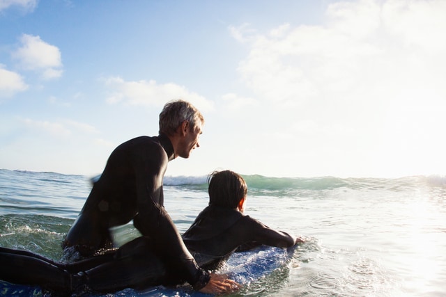 Abuelo enseña a su nieto a hacer surf.