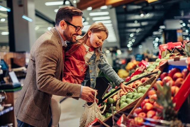 Padre e hija comprando fruta el supermercado.