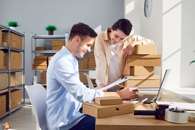 Compañeros de trabajo en la sala de correo revisando algunos paquetes.