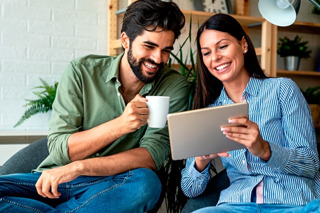 Pareja en casa revisando una tableta juntos.