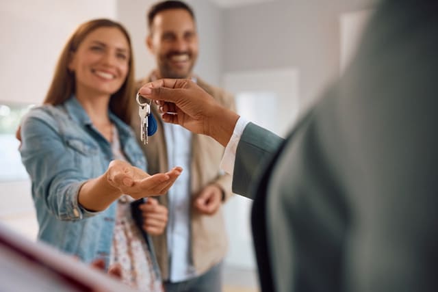 Pareja recibiendo las llaves de su nuevo auto.