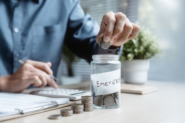 Una persona haciendo su contabilidad, metiendo monedas en pequeños botes.