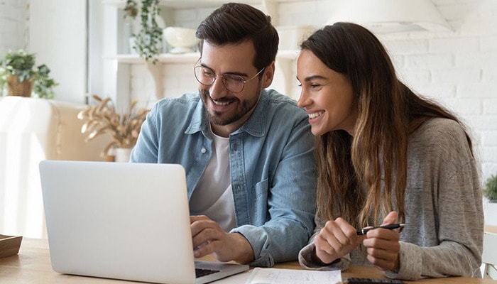 Una pareja en casa revisando sus finanzas.