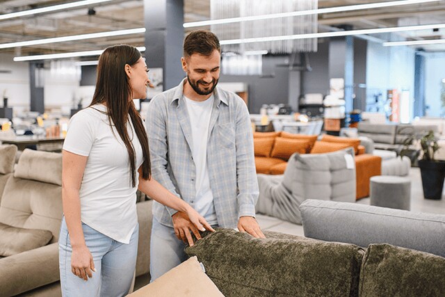 Una pareja elige un sofá nuevo en una tienda de muebles.