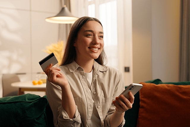 Mujer en casa comprando en línea desde su teléfono celular.