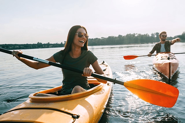 Pareja practicando kayak en un lago.