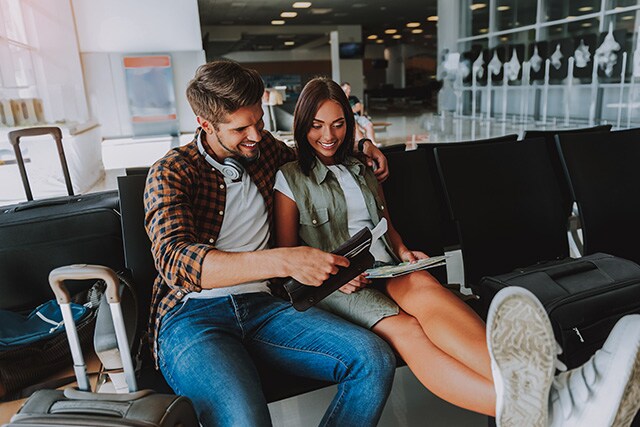 Pareja esperando su vuelo en un aeropuerto.