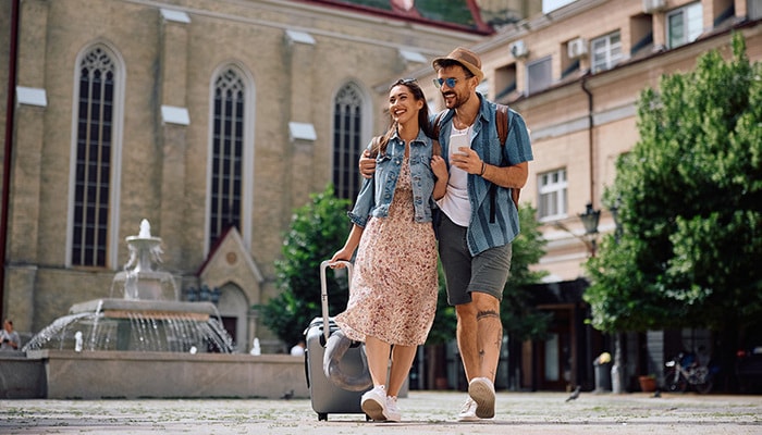 Una pareja caminando por una plaza empedrada en Europa.
