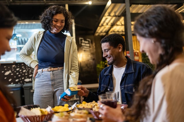 Hombre pagando la cena con tarjeta de crédito.