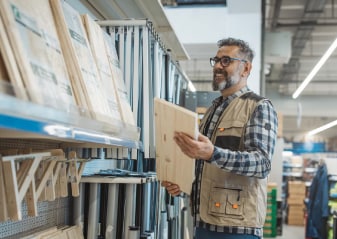 hombre sosteniendo tabla de madera en tienda