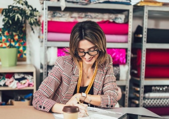 mujer escribiendo en negocio de textiles