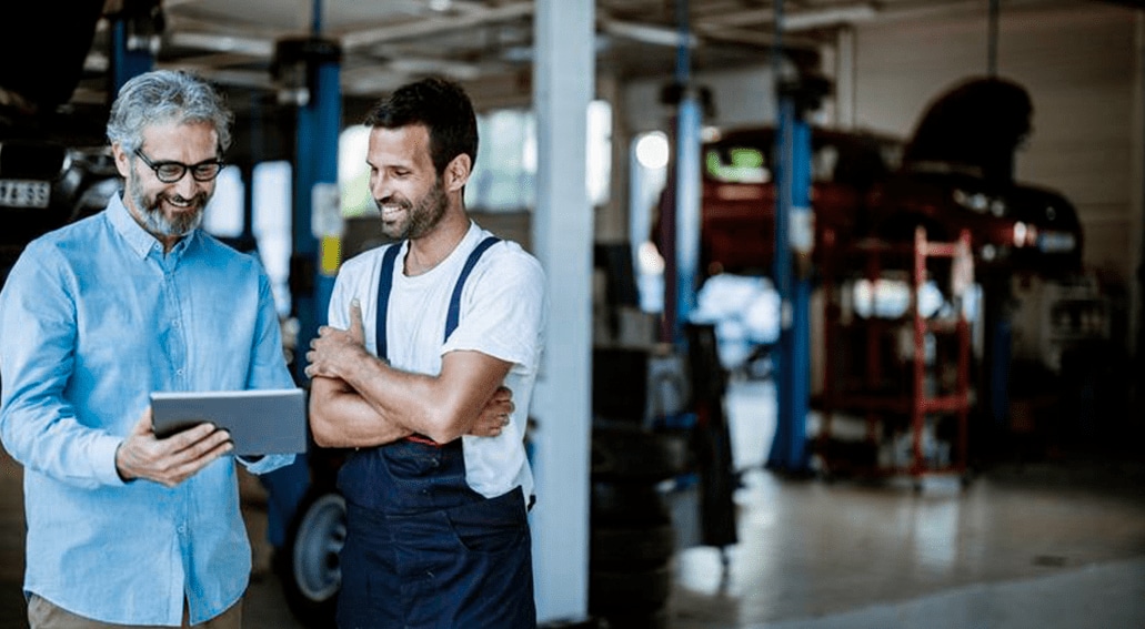 Hombres platicando en taller mecánico.