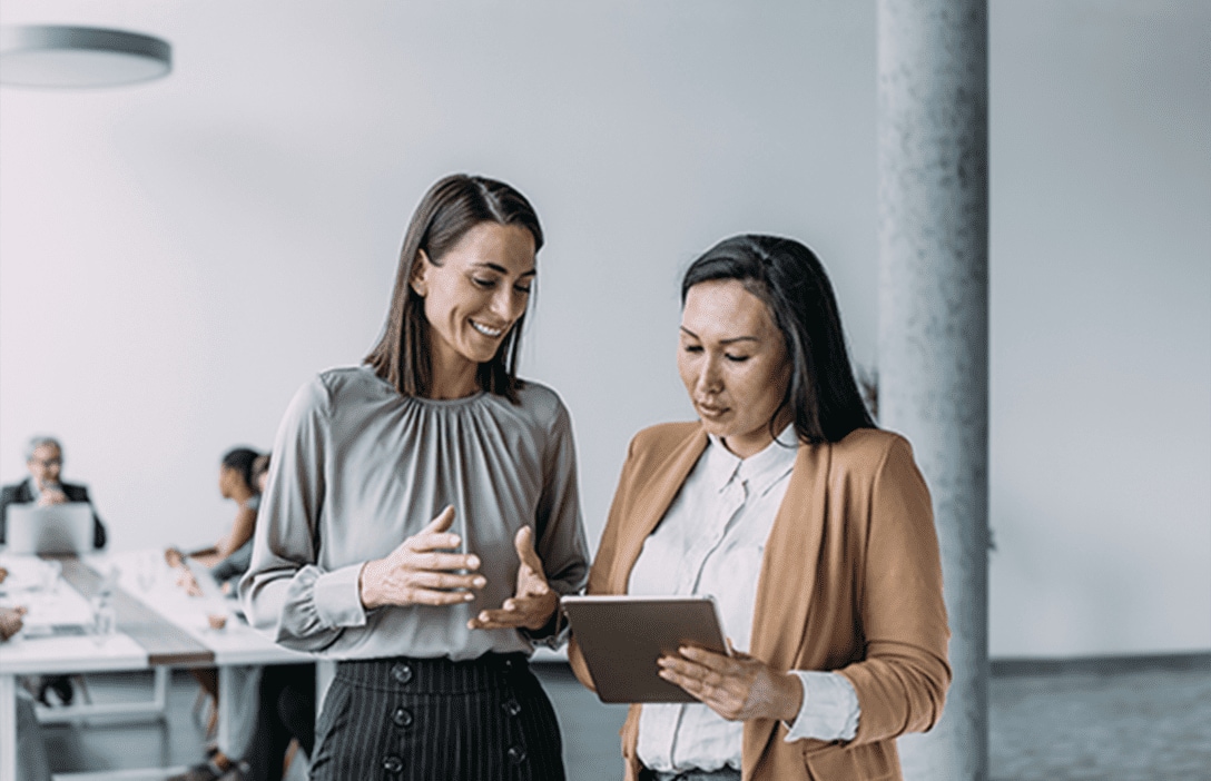 2 mujeres de pie en oficina.