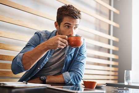 Persona comprando café con tarjeta American Express