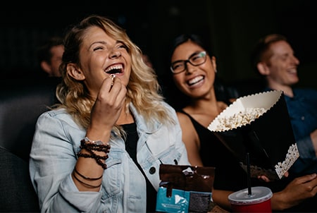 Personas viendo una película en el cine pagado con tarjeta American Express