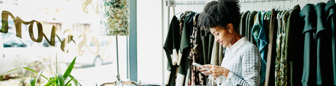 Plusieurs femmes souriant au téléphone dans un magasin de vêtements