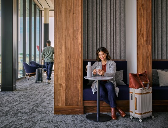 Femme au téléphone attendant dans un salon d’aéroport