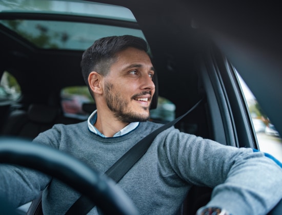 Homme souriant dans une voiture 