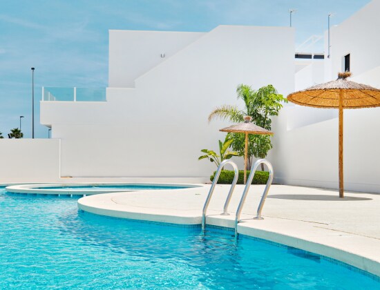 Piscine avec bâtiments blancs et palmiers