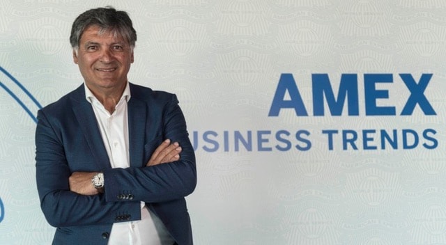 Toni Nadal entraineur et oncle de Raphael Nadal souri, les bras croisés. Derrière lui est affiché une bannière "American Express Business Trends"