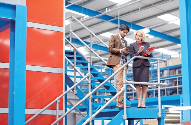 Two brewery workers evaluating barrels