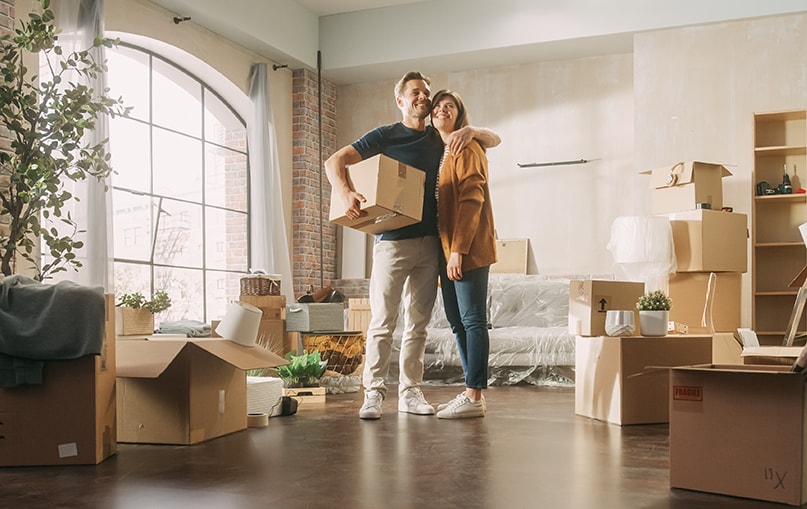 giovane coppia si abbraccia nel proprio nuovo appartamento       