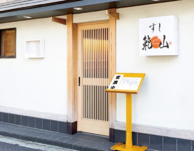 Outside of a restaurant with logo and menu stand