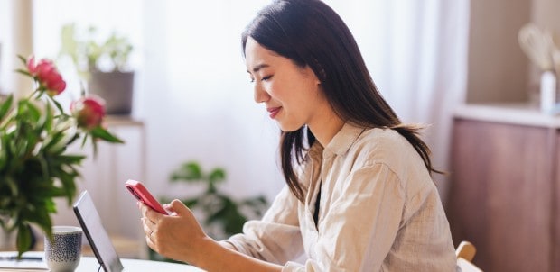 室内でスマートフォンを操作する女性