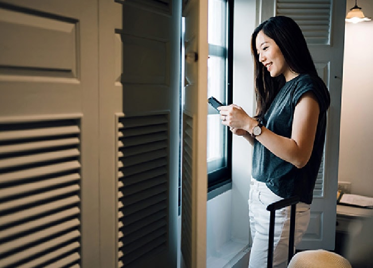 スマートフォンで旅行の手配をする女性