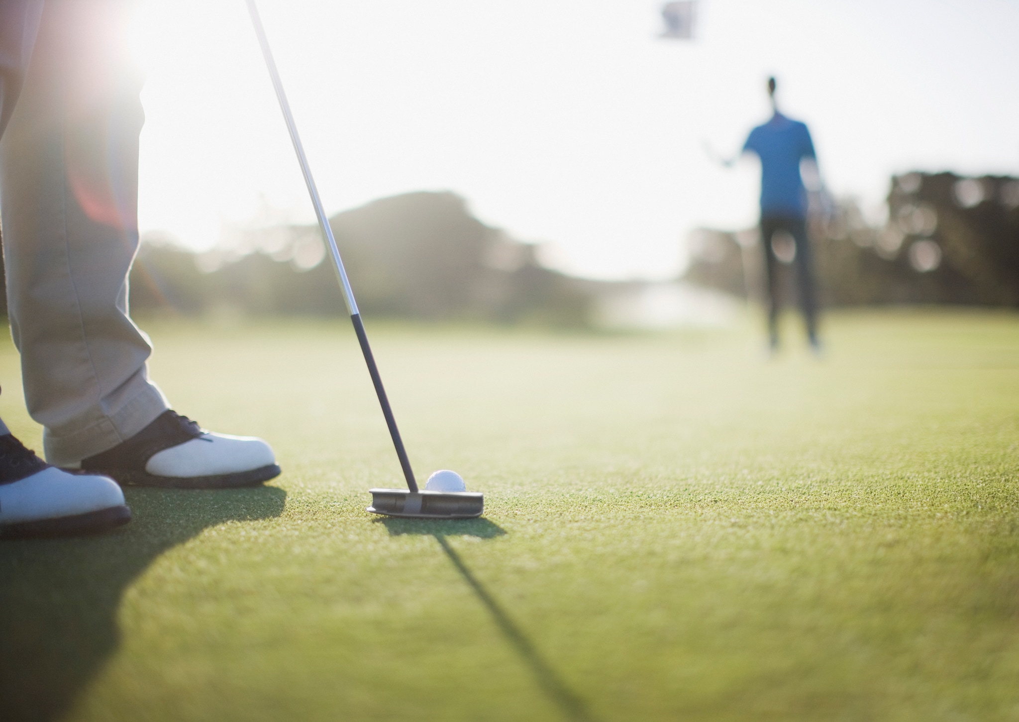 Man putting golf ball (mid level view of man)