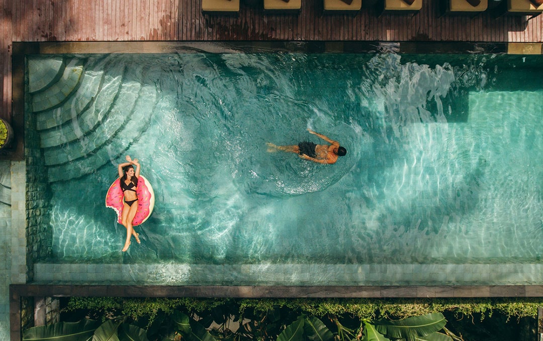 Pareja en alberca de vacaciones - American Express